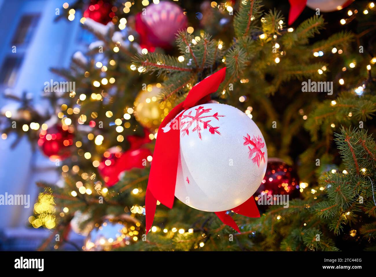 Christmas tree with red balloons on city street at night Stock Photo ...