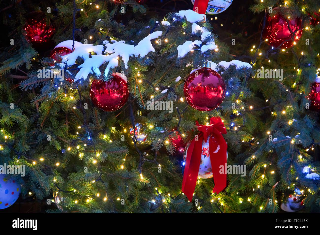 Christmas tree with red balloons on city street at night Stock Photo ...