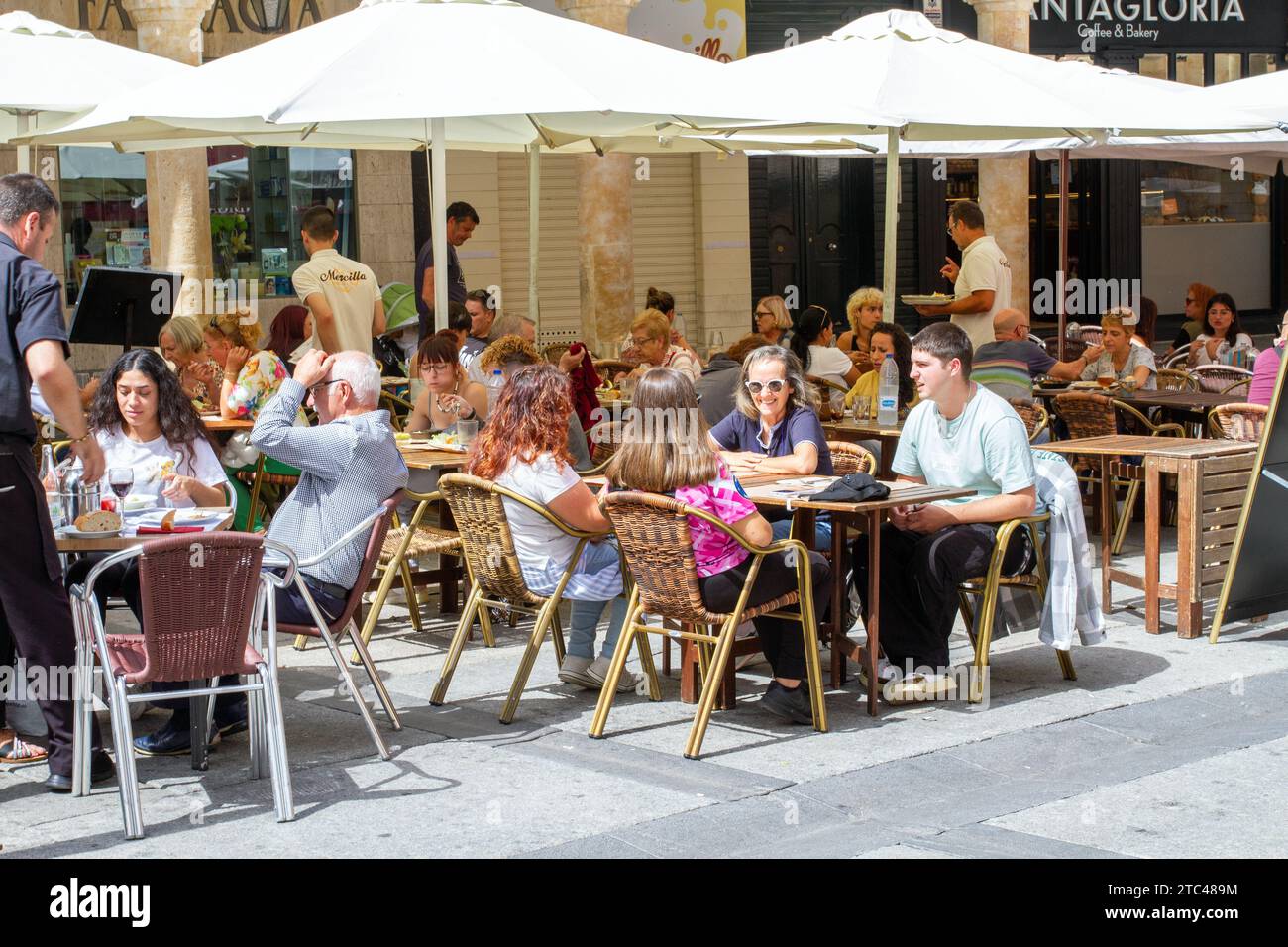 People sitting outside in the sunshine eating and drinking in the Plaza
