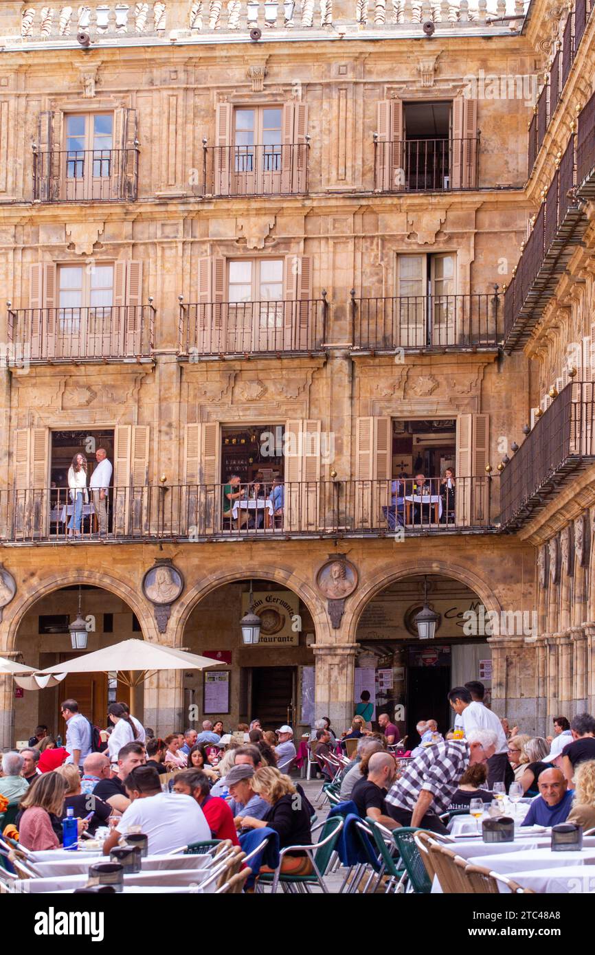 People sitting outside in the sunshine eating and drinking in the Plaza
