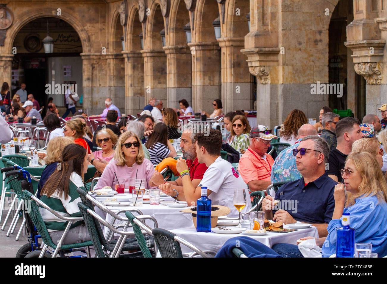 People sitting outside in the sunshine eating and drinking in the Plaza