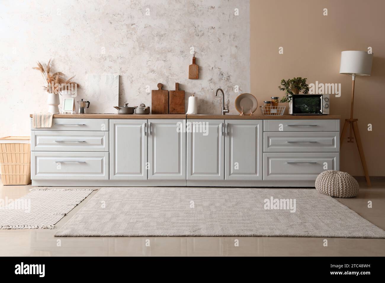 White counters with sink, microwave oven and utensils in modern kitchen ...