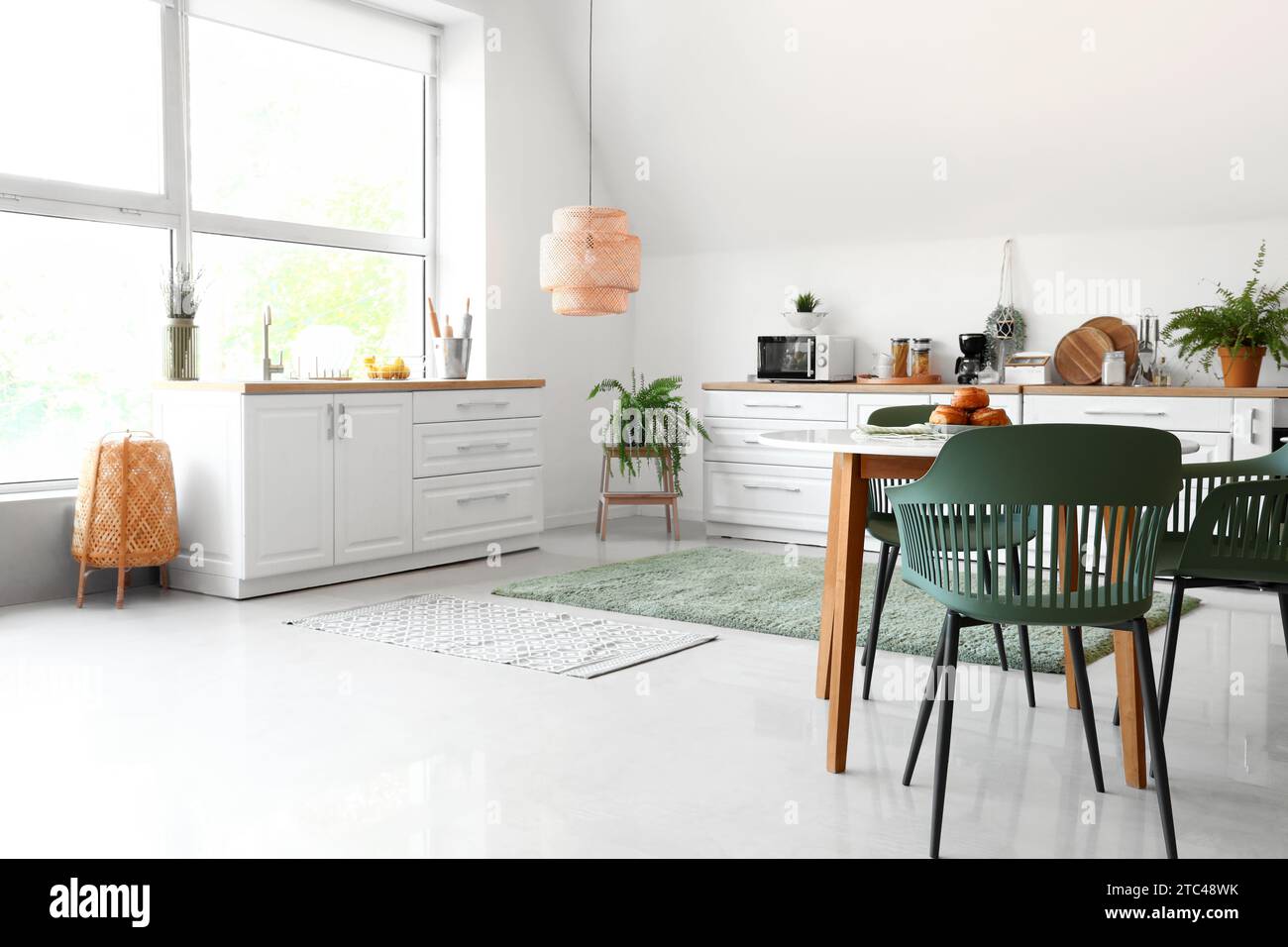 Interior of modern kitchen with white counters and dining table Stock ...