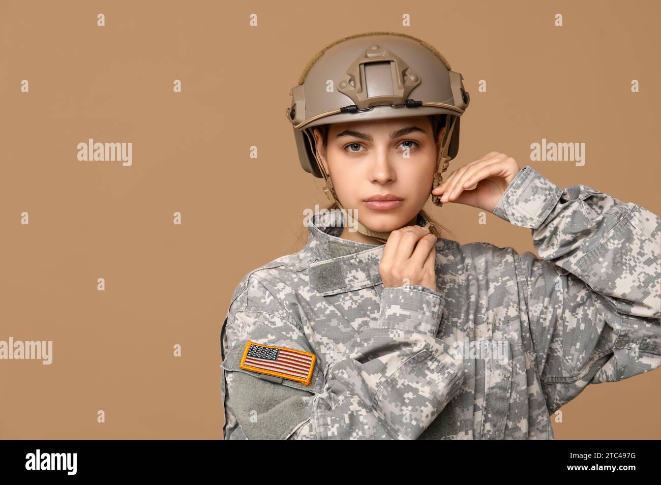 Confident young female soldier in uniform on beige background Stock ...