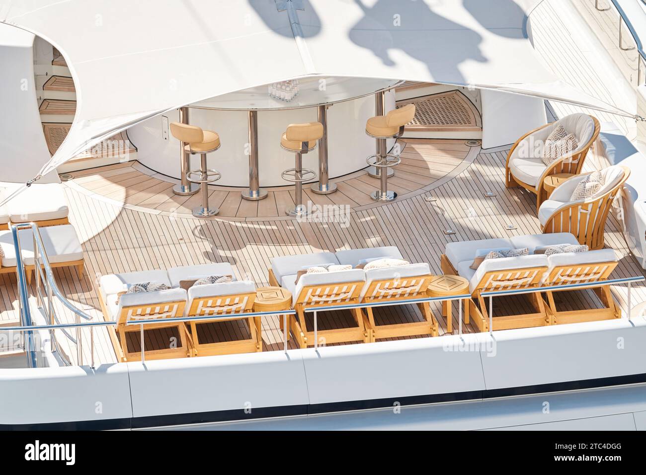 Close up footage of a relaxation area on the open teak deck of an expensive megayacht at sunny day, with awnings stretched over the deck to protect Stock Photo