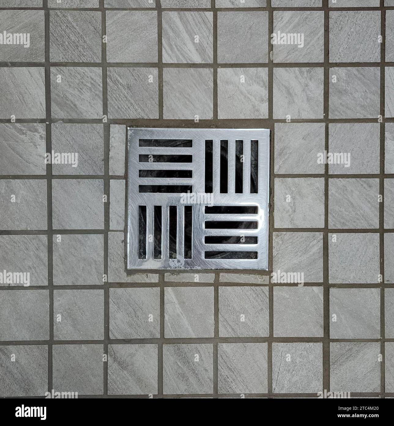 Shower stall floor drain stainless steel with tiled ground Stock Photo