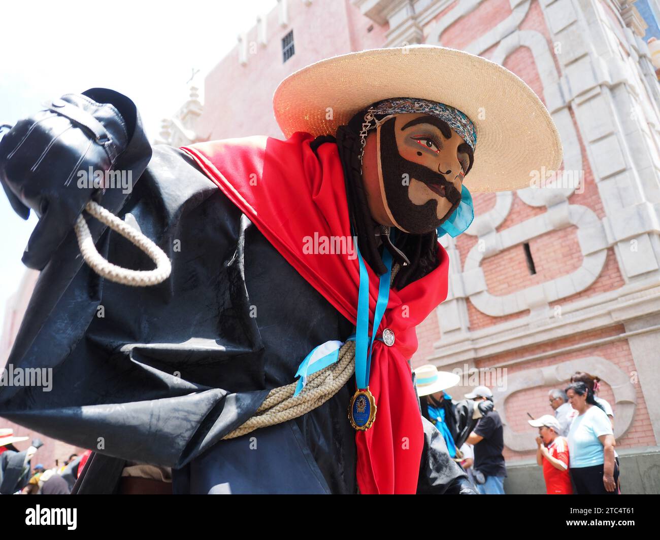 Man with mask and whip from an indigenous Peruvian folk dance group performing the 'Danza de los Arrieros' (Dance of the Muleteers) through the streets of the historic center of Lima as part of the Municipality of Lima program to disseminate the Andean cultural heritage. Stock Photo
