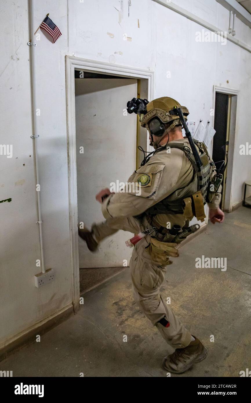 A member of the Task Force Viking's Norwegian Telemark Battalion QRF kicks in a door at Al Asad Air Base, Iraq, Nov. 21, 2023. Task Force Viking was ensuring there were no occupants inside the room after a building was struck by enemy indirect fire. (U.S. Army photo by Staff Sgt. Quince Lanford) Stock Photo