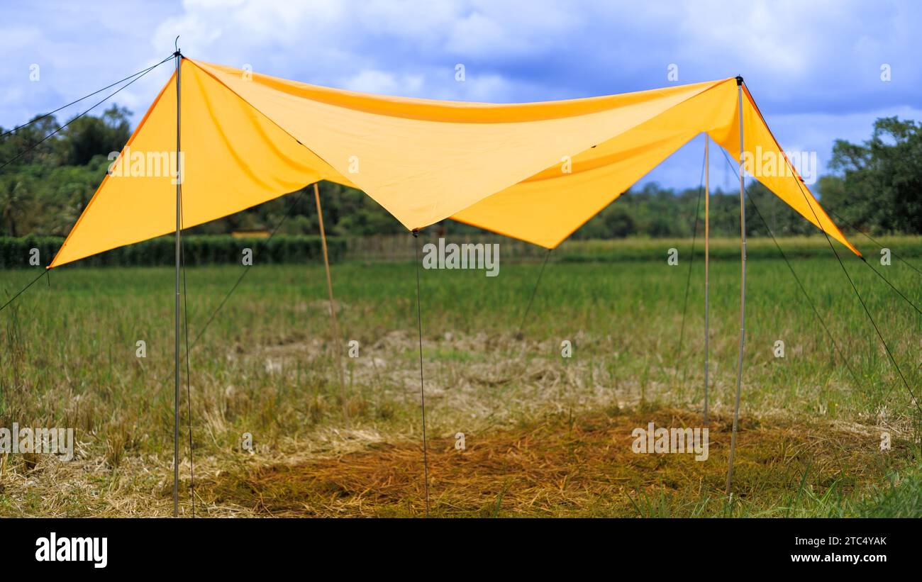Yellow tent or marquee with aluminum rod support on open grass field