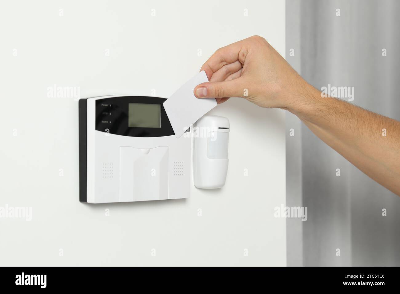 Home security system. Man using key card indoors, closeup Stock Photo