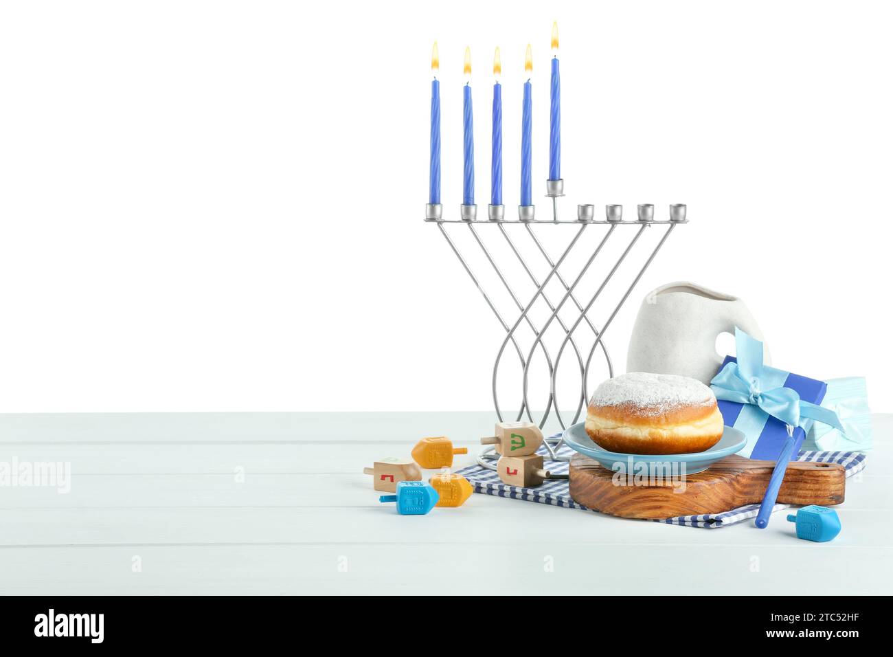 Hanukkah celebration. Composition with menorah, dreidels and donut on