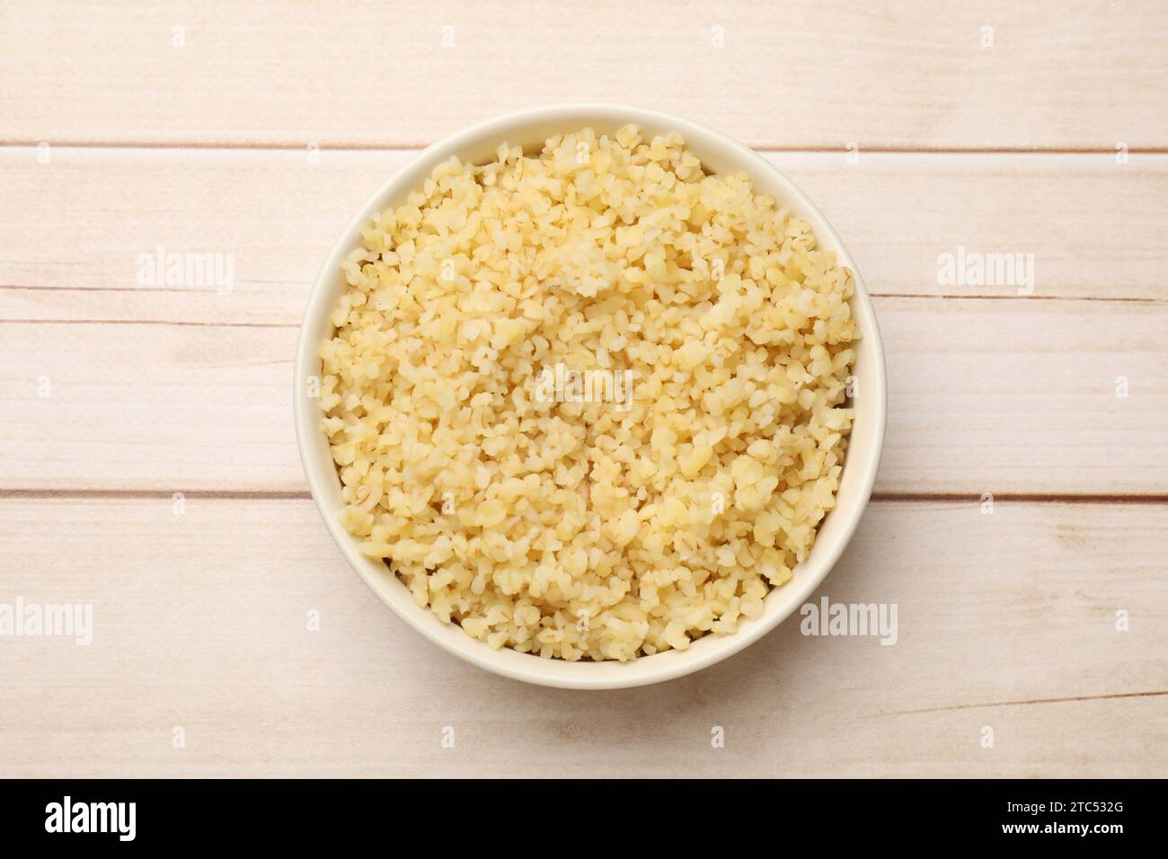 Bulgerty Eatable Delicious bulgur in bowl on wooden table, top view Stock Photo - Alamy