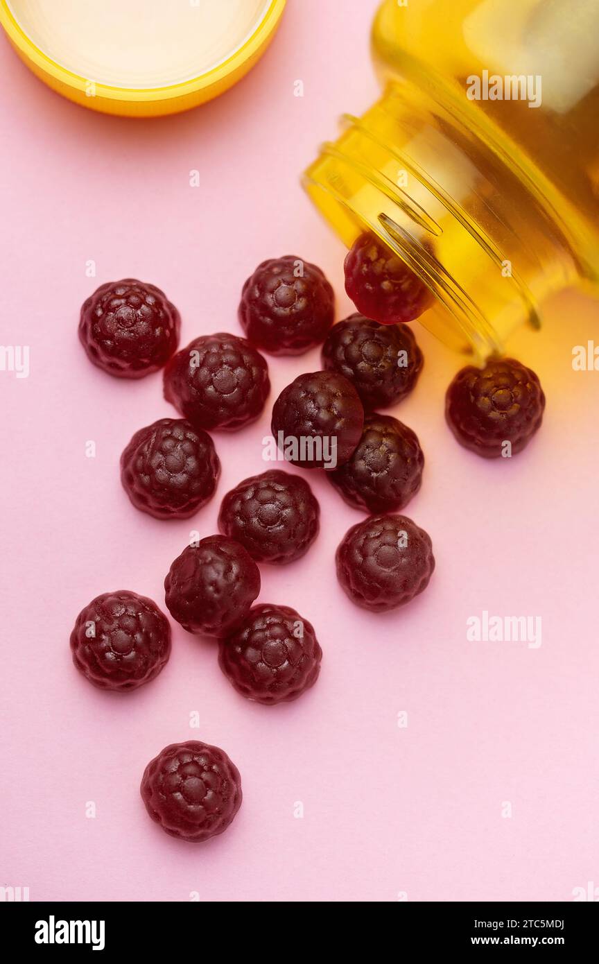 Vitamins for children, jelly gummy fruits candy on pink background