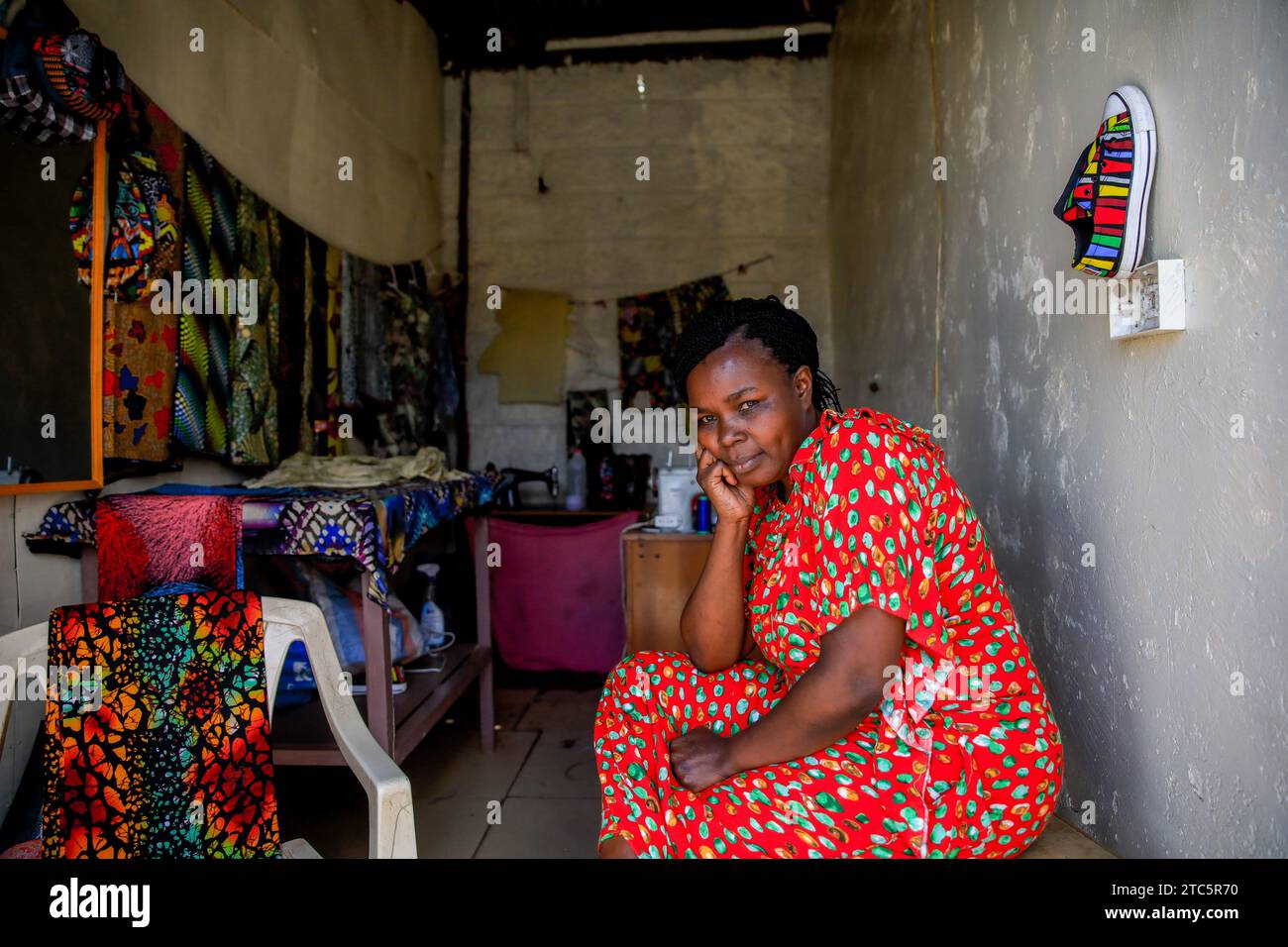Beatrice Anyango a tailor at Afrowema is seated at her stall in Kibera