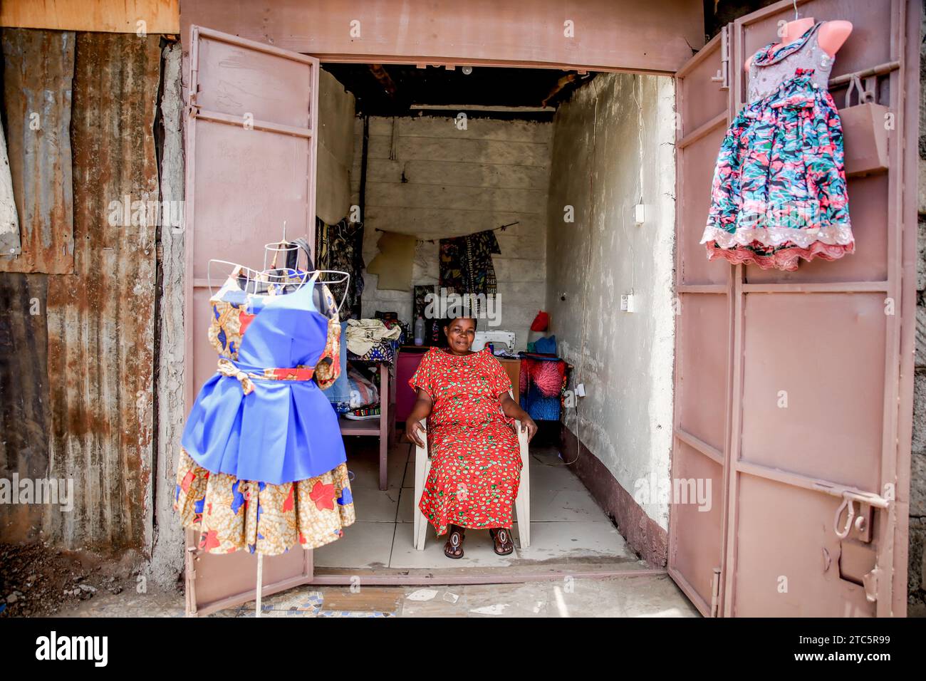 Beatrice Anyango a tailor at Afrowema is seated at her stall in Kibera