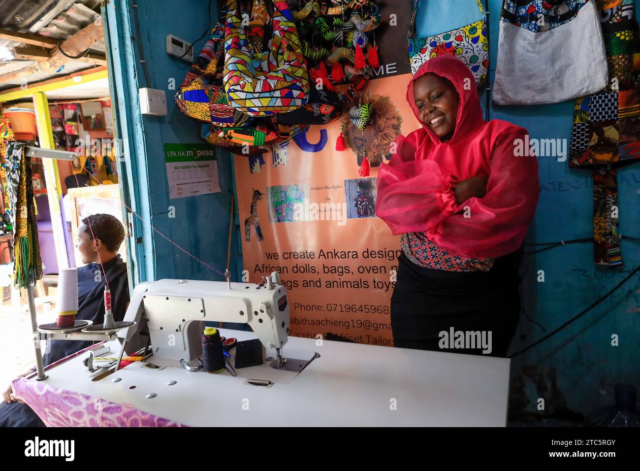 Tabitha Achieng, a tailor from kibera is posed for a photo at her shop