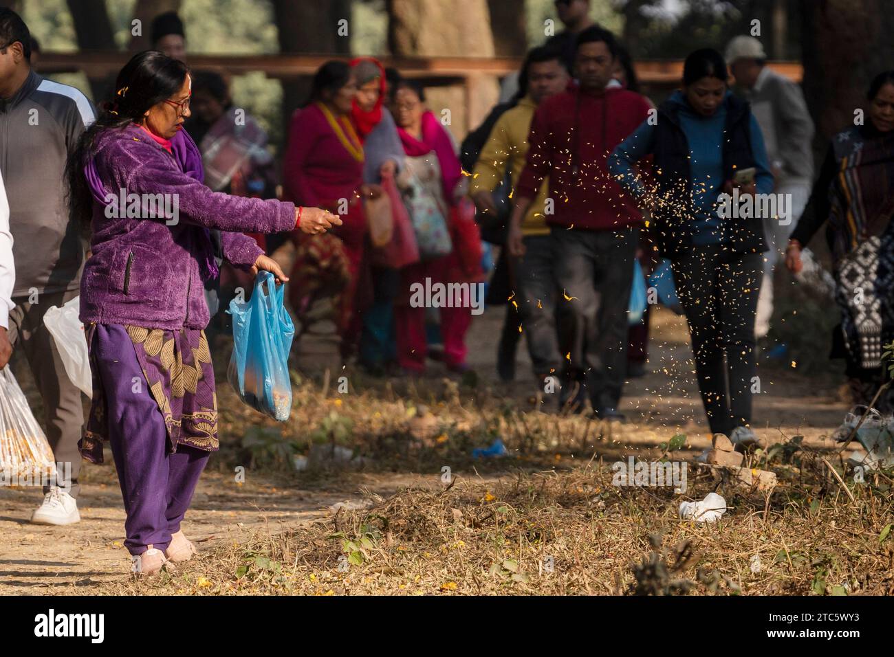 Kathmandu, Nepal. 11th Dec, 2023. A woman scatters a mixture of seven