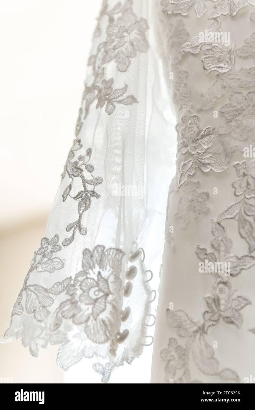 A white wedding dress with delicate lace detailing on the sleeves Stock  Photo - Alamy