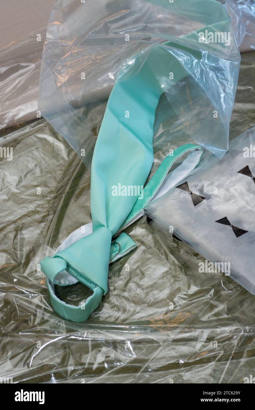 A close-up of a glossy blue silk tie, partially unwrapped from its packaging Stock Photo