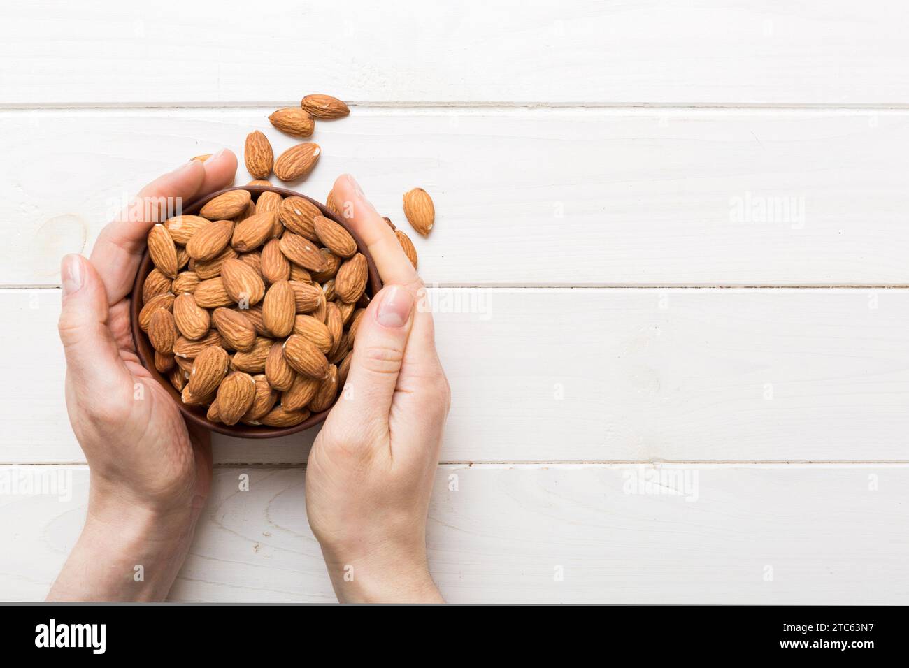 Woman hands holding a wooden bowl with almond nuts. Healthy food and ...