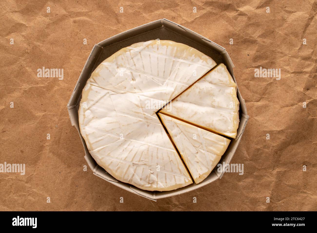 Fragrant brie cheese with paper packaging on kraft paper, macro, top view Stock Photo Alamy