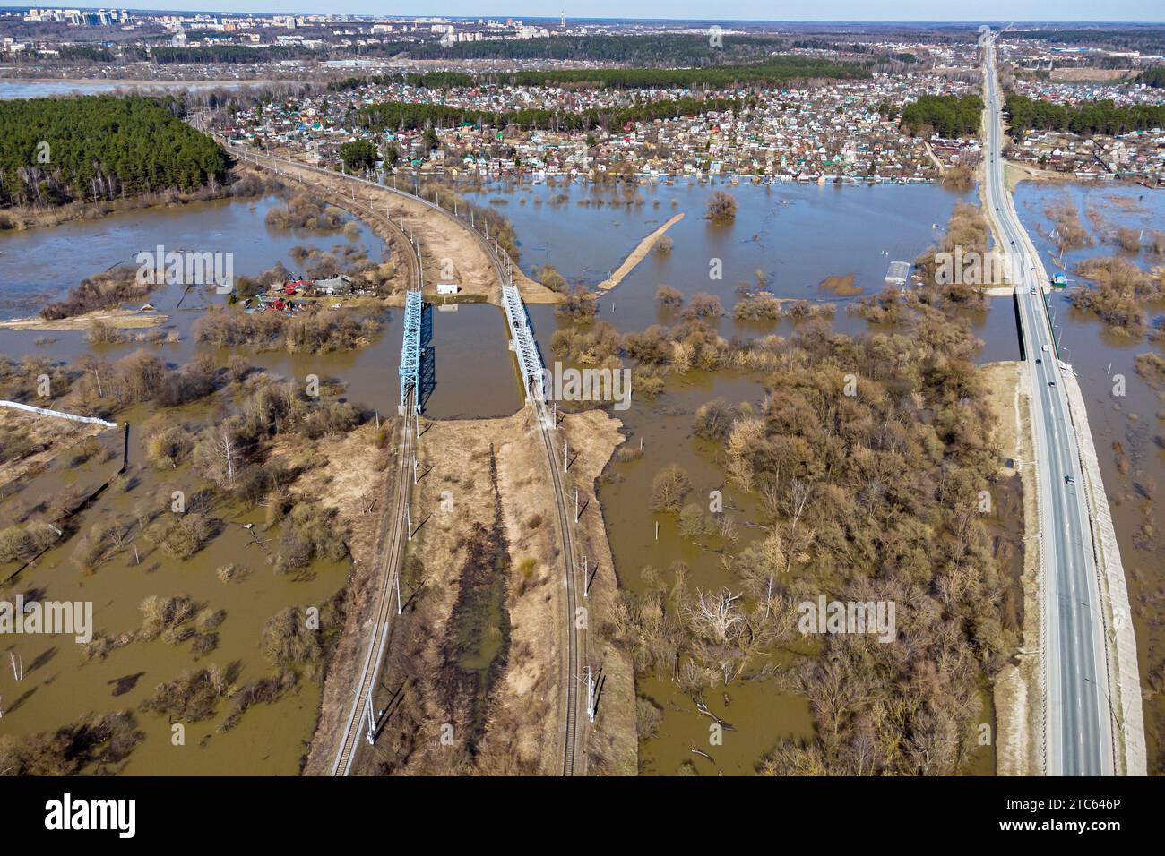 A countryside area with a road and a railway flooded during the spring ...