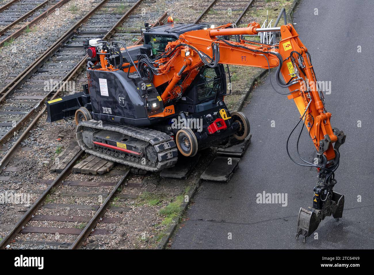 Nancy, France - Orange and grey road-rail crawler excavator D2R ZX135C PRR at the railway depot at Nancy station. Stock Photo