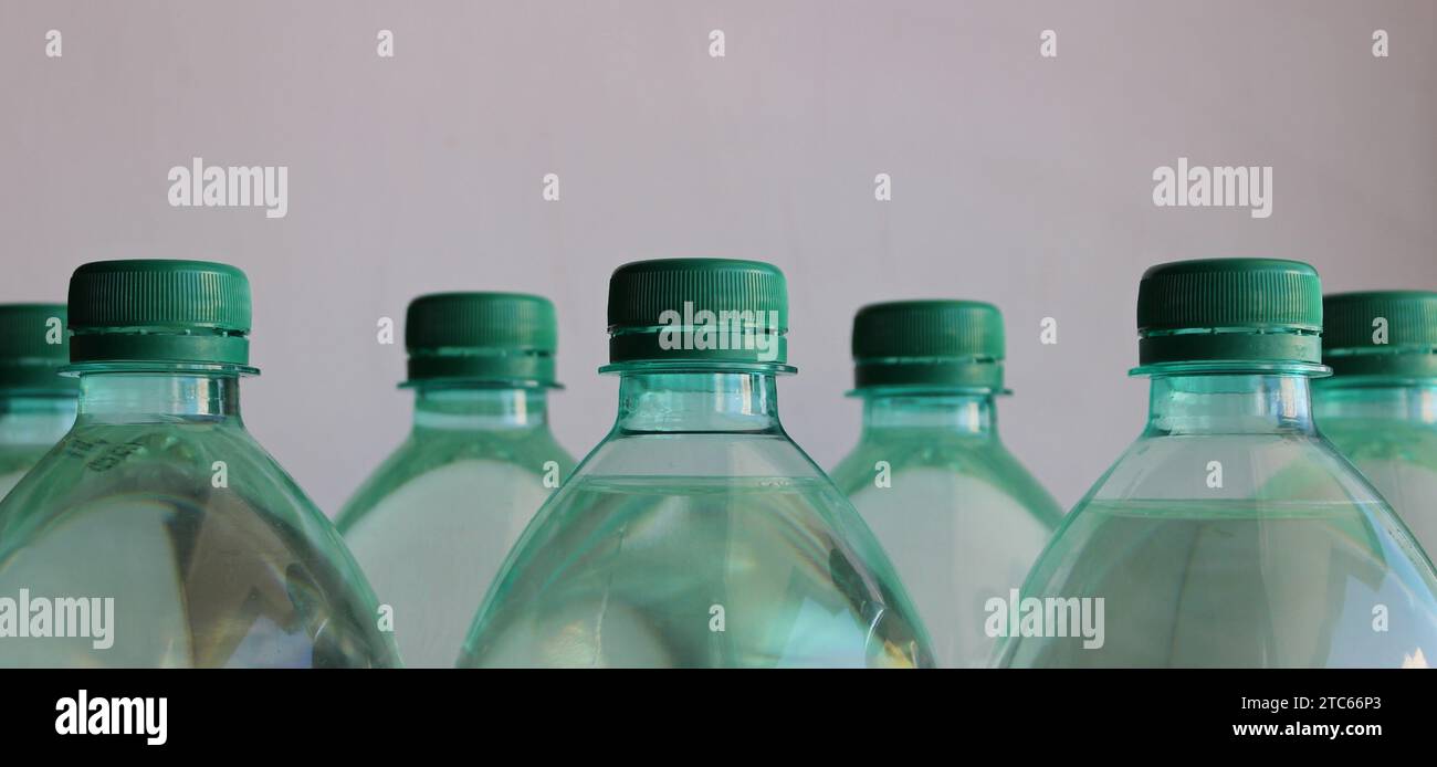 Green Caps Of Plastic Bottles Filled With Water Closeup Side View Stock