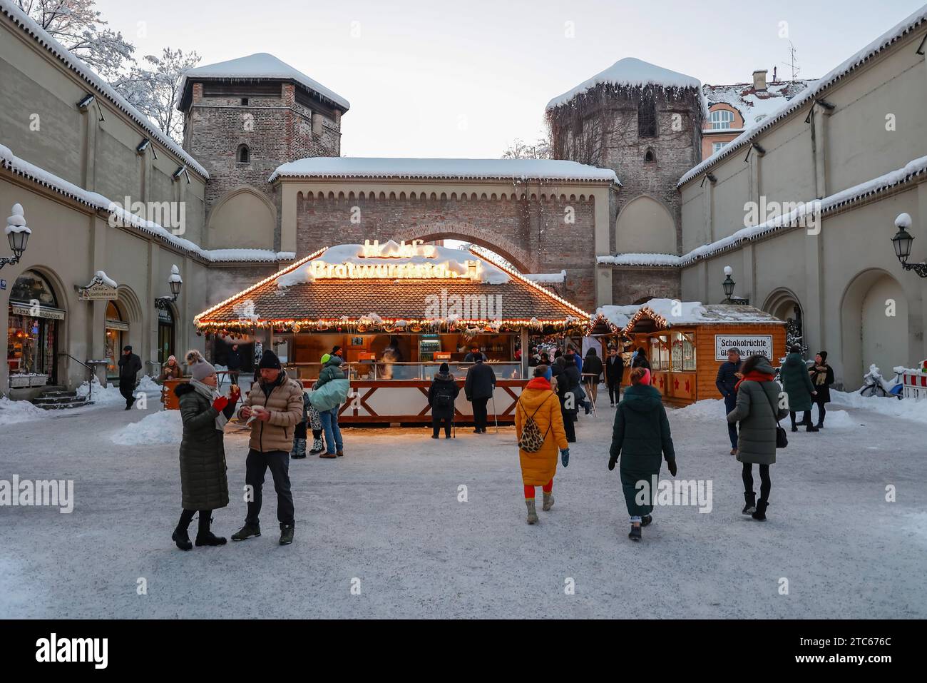 Shoppers and Christmas market food stall in city centre  next to Sendlinger Tor (city gate) in Munich, Bavaria, Germany, Europe Stock Photo