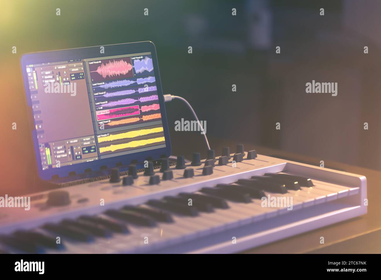 Musical keyboard and tablet in a dark room, music production Stock ...