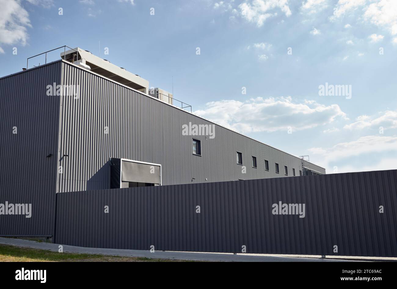 Corrugated steel warehouse or factory industrial building against blue