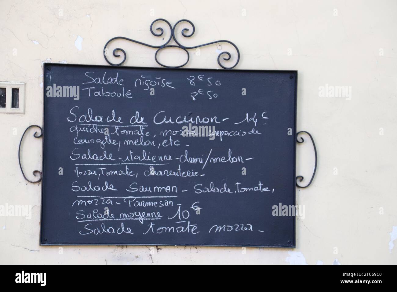 A close-up of a menu displayed on a chalkboard wall outside a cozy cafe Stock Photo