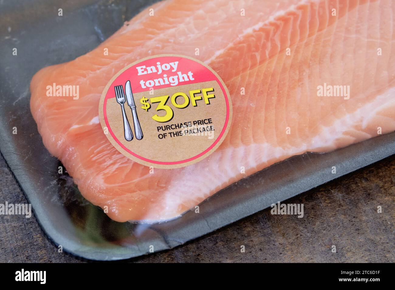 Fish filet with sticker $3 off 'Enjoy Tonight' selling produce before best before date Stock Photo