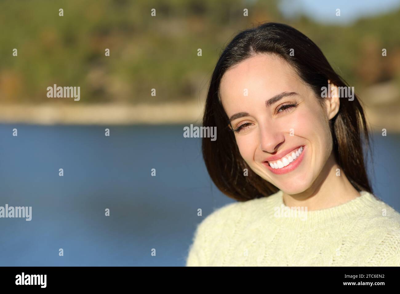 Portrait of a happy woman smiling at camera standing in a lake Stock Photo