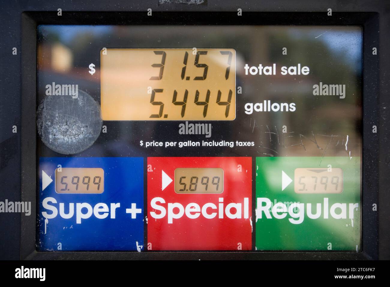 High gas prices reflected in sign at a gas station as drivers fill up