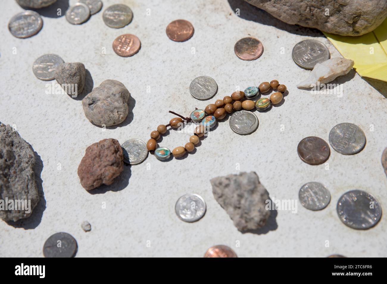 Coins and rosary at memorial atâ€ Manzanar, Independence, California, USA Stock Photo