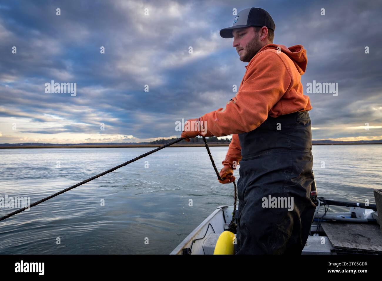 Commercial fisherman wearing waders working in fishing boat Stock Photo