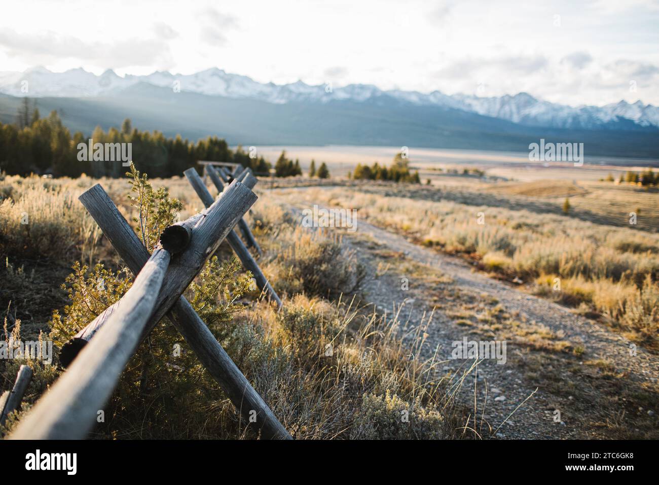 Sunset rays peeking through rustic fence in Idaho wilderness Stock Photo