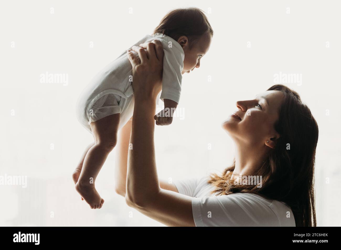 Side view of mom holding baby up Stock Photo