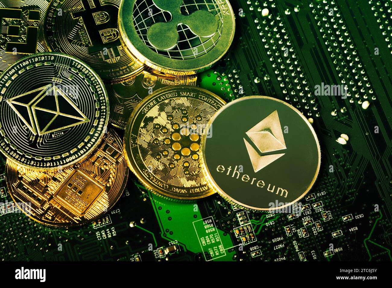 Selection of cryptocurrency token coins with a circuit board background Stock Photo