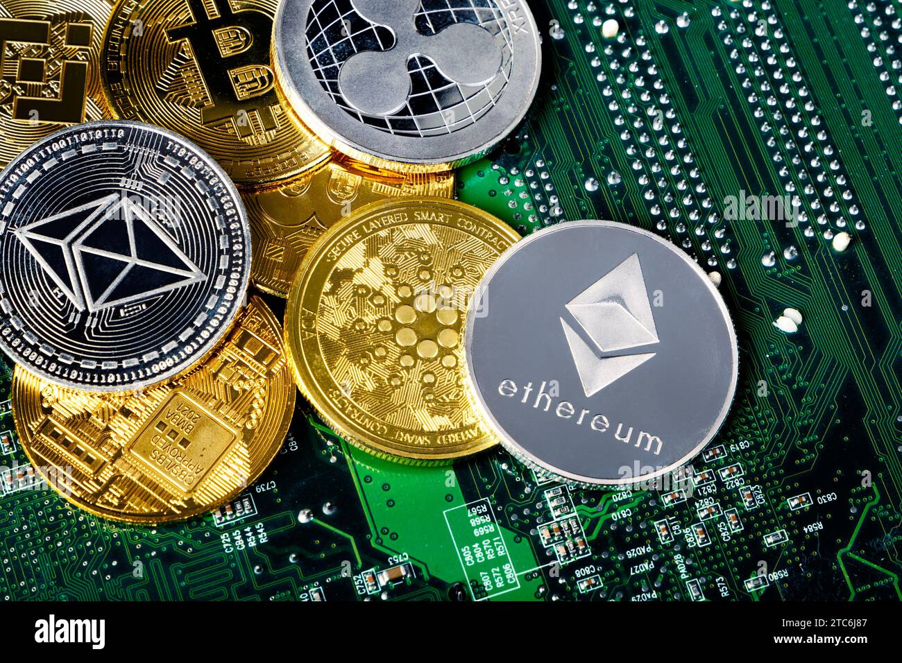 Selection of cryptocurrency token coins with a circuit board background Stock Photo
