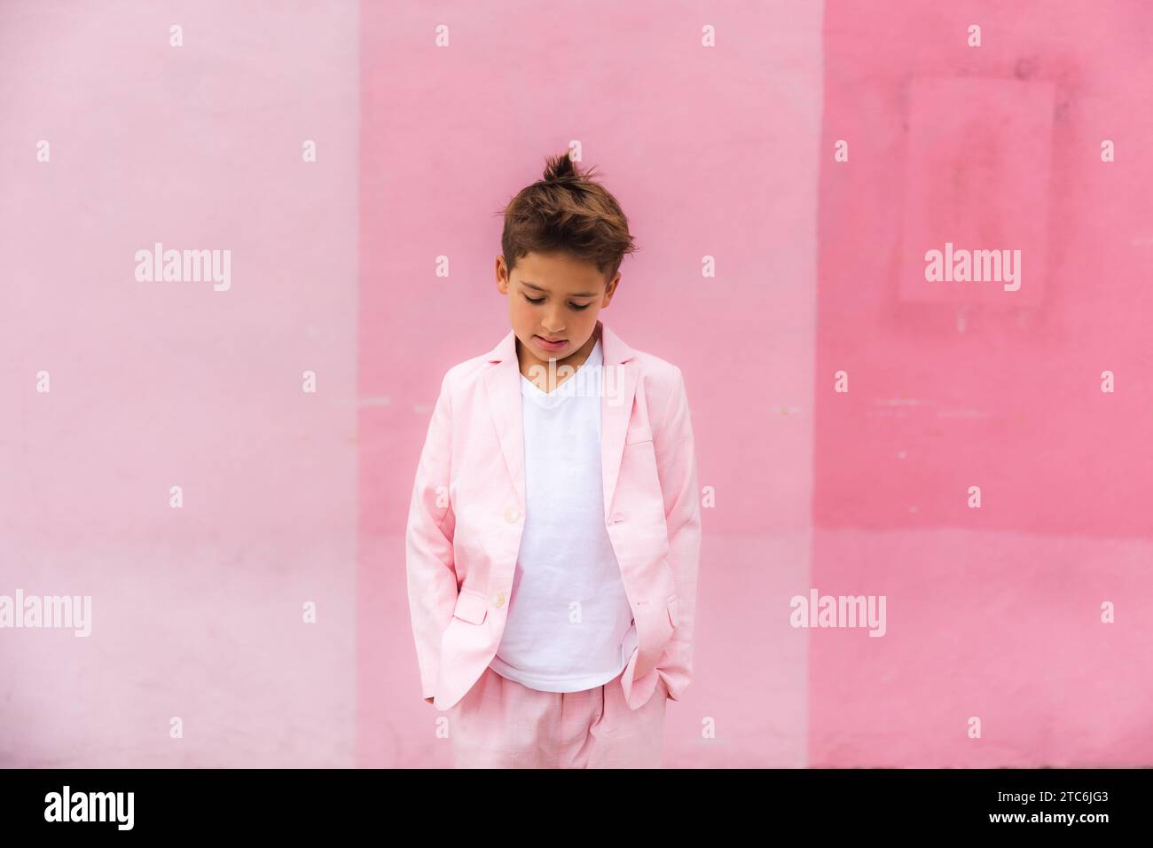 Young boy all pink posing on the sidewalk in a suit Stock Photo