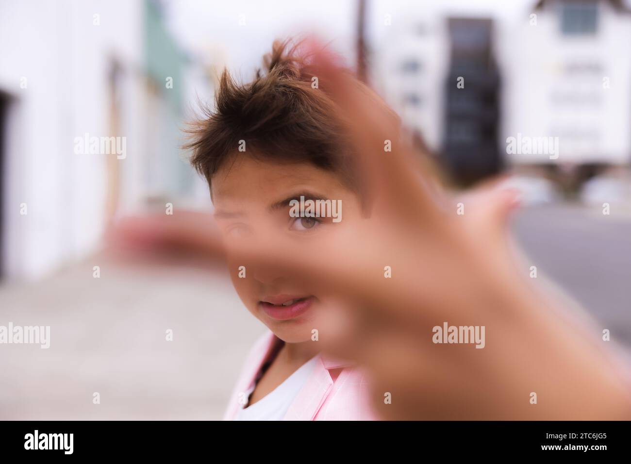 Young boy all pink posing on the sidewalk in a suit Stock Photo