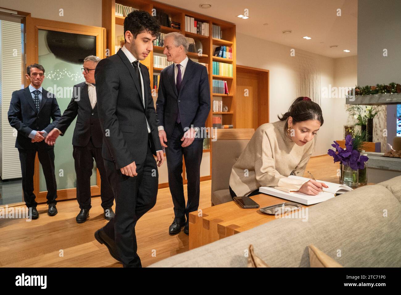 Oslo 20231211.The family of peace prize winner Narges Mohammadi, from left: brother Hamidreza Mohammadi, husband Taghi Rahmani, son Ali Rahmani and daughter Kiana Rahmani sign the visit protocol before a breakfast meeting with Prime Minister Jonas Gahr Stoere in the government's representation facility. Photo: Heiko Junge / NTB POOL Stock Photo