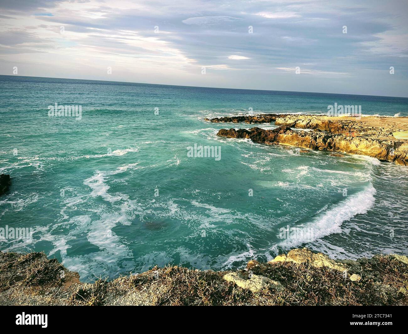 A stunning seascape with rocky cliffs and crystal blue waters Stock Photo