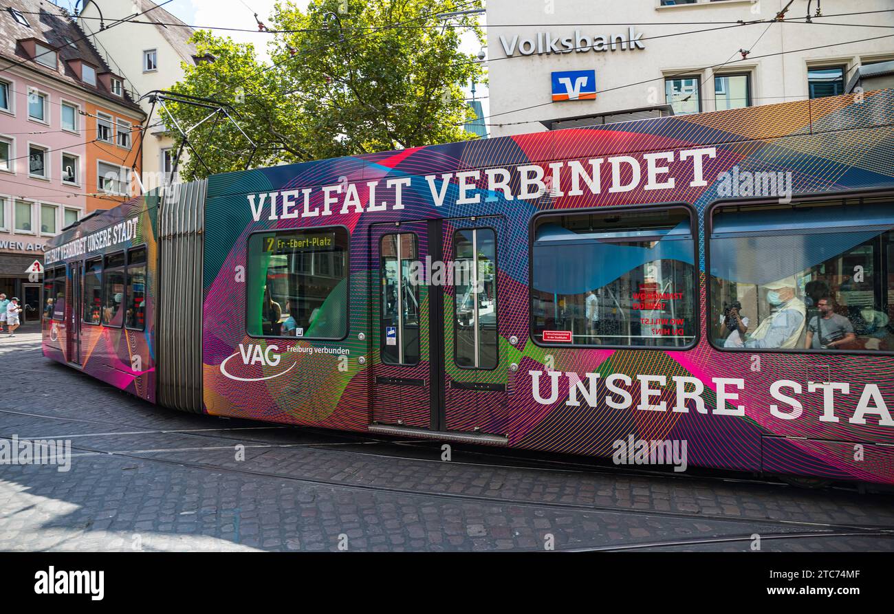 Strassenbahn Eine Strassenbahn der Linie 2 ist in den Strassen von Freiburg im Breisgau unterwegs. Das Tram trägt Werbung, dass die Vielfalt die Stadt verbindet. Freiburg im Breisgau, Deutschland, 07.08.2022 *** Streetcar A streetcar on line 2 is on the streets of Freiburg im Breisgau The streetcar carries advertising that diversity connects the city Freiburg im Breisgau, Germany, 07 08 2022 Credit: Imago/Alamy Live News Stock Photo