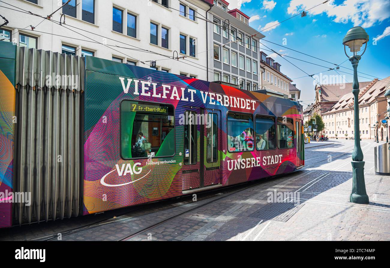 Strassenbahn Eine Strassenbahn der Linie 2 ist in den Strassen von Freiburg im Breisgau unterwegs. Das Tram trägt Werbung, dass die Vielfalt die Stadt verbindet. Freiburg im Breisgau, Deutschland, 07.08.2022 *** Streetcar A streetcar on line 2 is on the streets of Freiburg im Breisgau The streetcar carries advertising that diversity connects the city Freiburg im Breisgau, Germany, 07 08 2022 Credit: Imago/Alamy Live News Stock Photo
