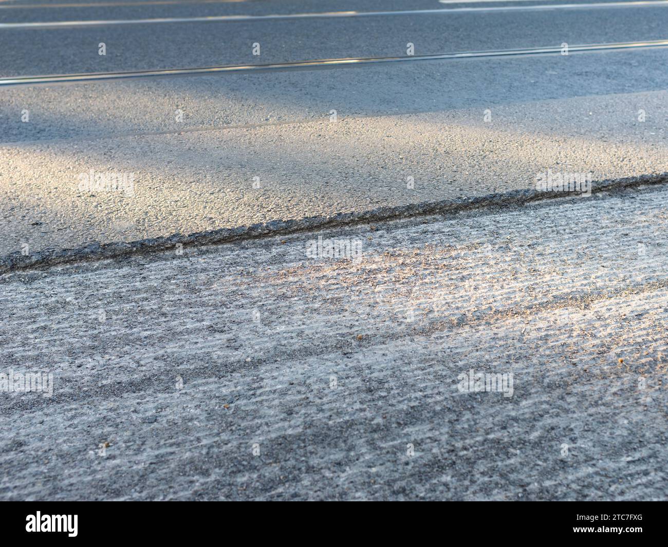 Asphalt milling of a street close up. A step to the surface layer is