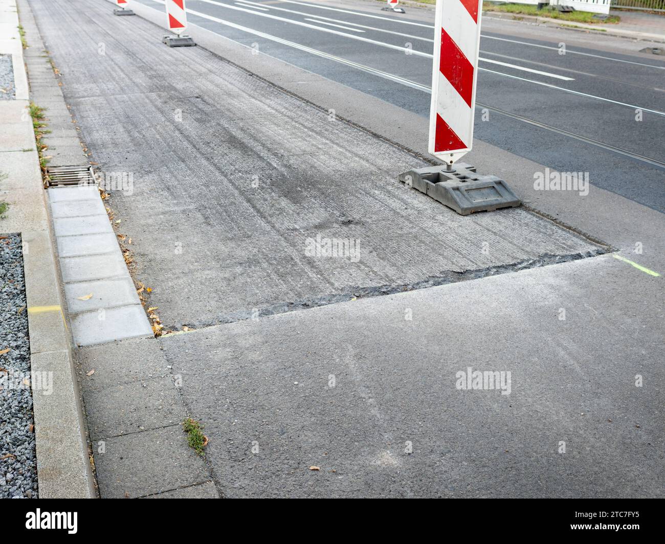 Asphalt milling of a street in the city. The upper layer has been milled down to renew the surface. Maintenance of a road in the town. Stock Photo