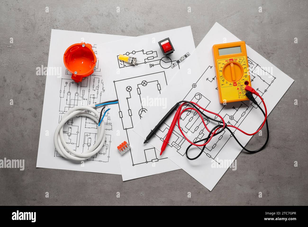 Wiring diagrams, digital multimeter and other electrician's equipment on grey table, flat lay Stock Photo